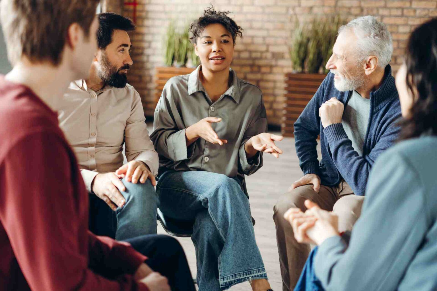 People participating in a peer group discussion during addiction treatment