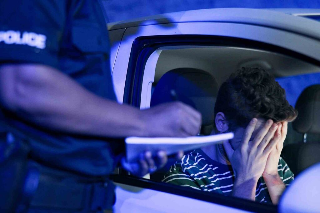 Police officer speaking with an impaired driver during a nighttime traffic stop in Florida