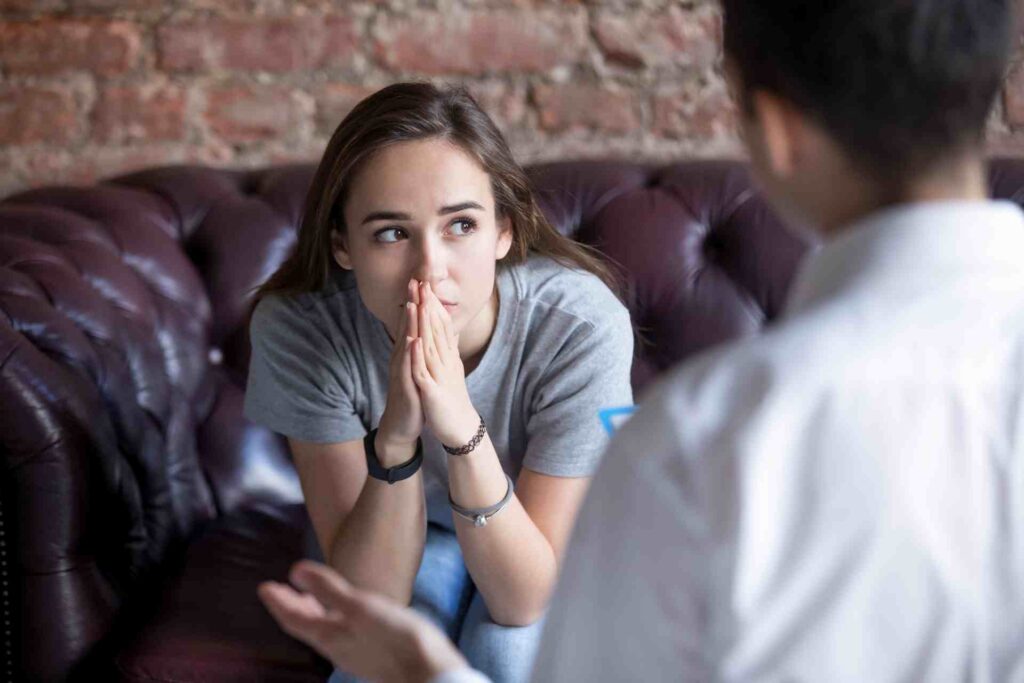 Young woman speaking with a therapist before starting addiction treatment