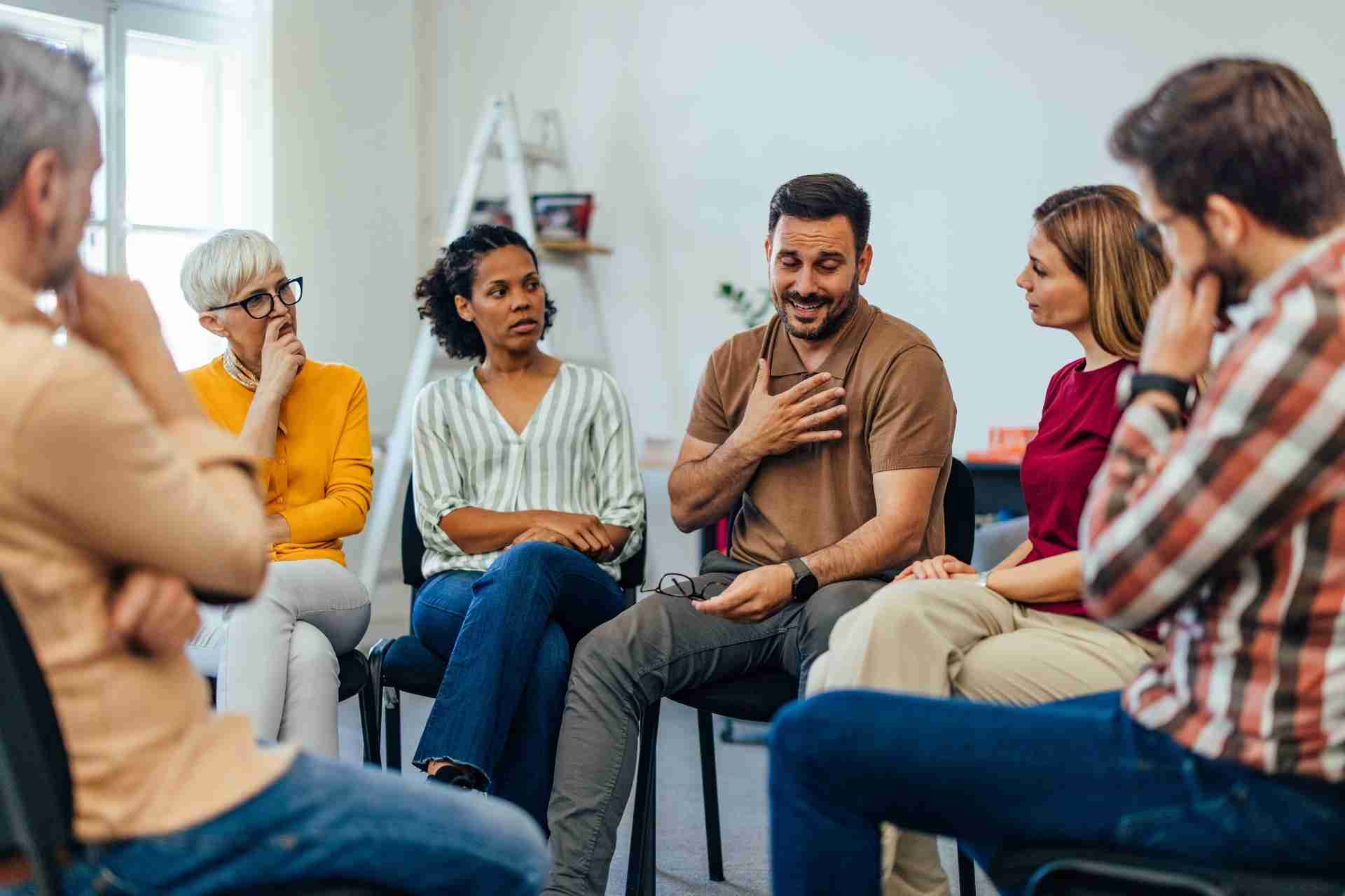 People participating in a group therapy session for addiction recovery and emotional support